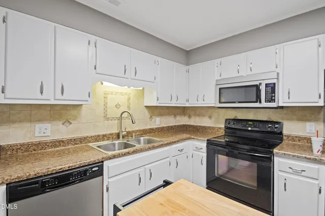 a kitchen with a table chairs refrigerator and cabinets