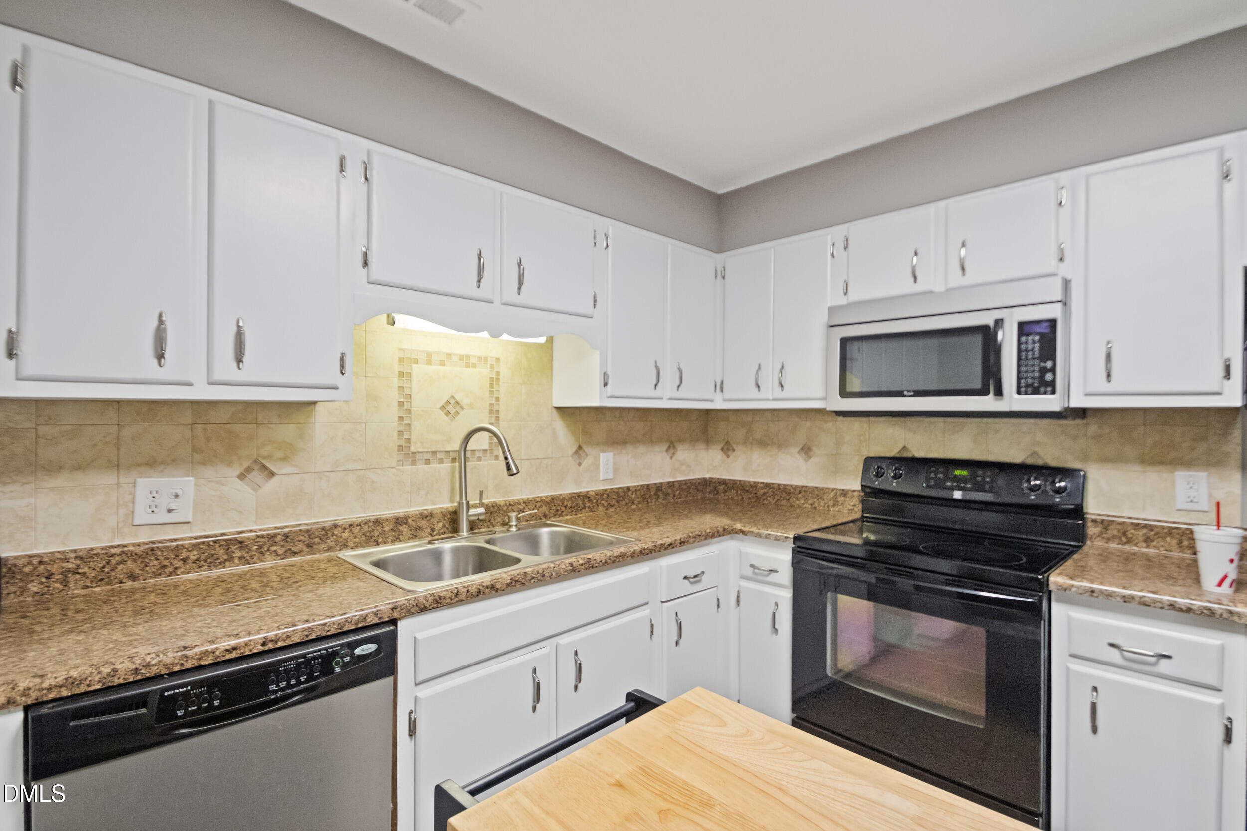 5909 Spinner Road Hope Mills, NC 28348 - Photo 12 of 24 a kitchen with granite countertop white cabinets and stainless steel appliances