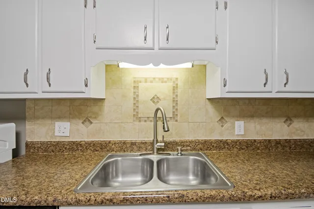 a kitchen with granite countertop a sink stove and refrigerator