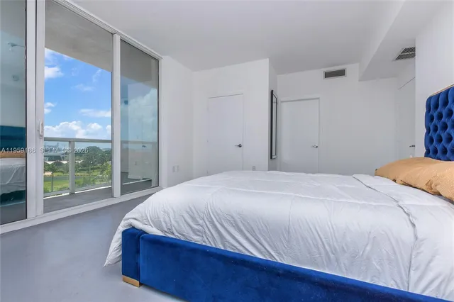 a bedroom with a bed and a large window