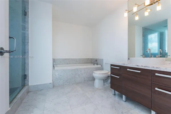a bathroom with a granite countertop toilet a sink and a mirror