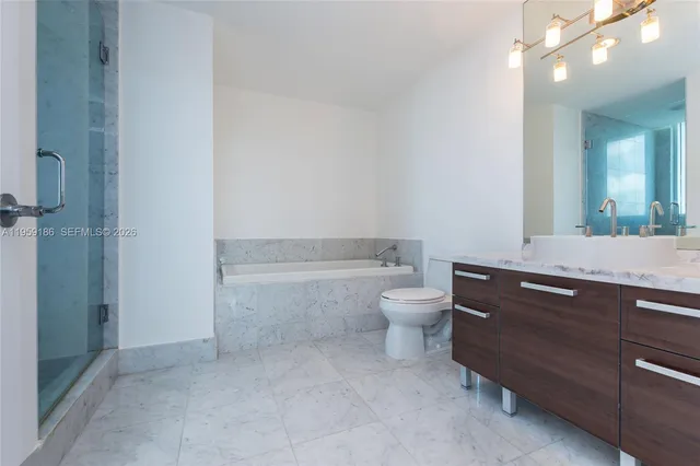 a bathroom with a granite countertop toilet a sink and a mirror