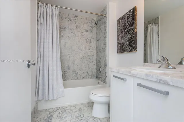 a bathroom with a granite countertop sink a toilet and shower