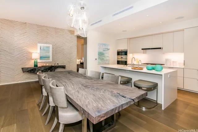 a dining room with kitchen island a table and chairs in it