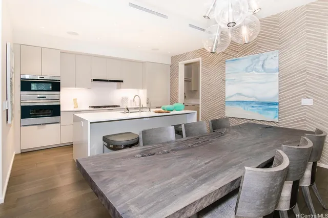 a kitchen with kitchen island a stove a sink a refrigerator dining table and chairs