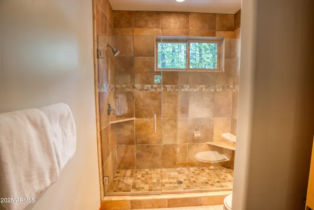 a bathroom with a granite countertop sink a large mirror and a shower