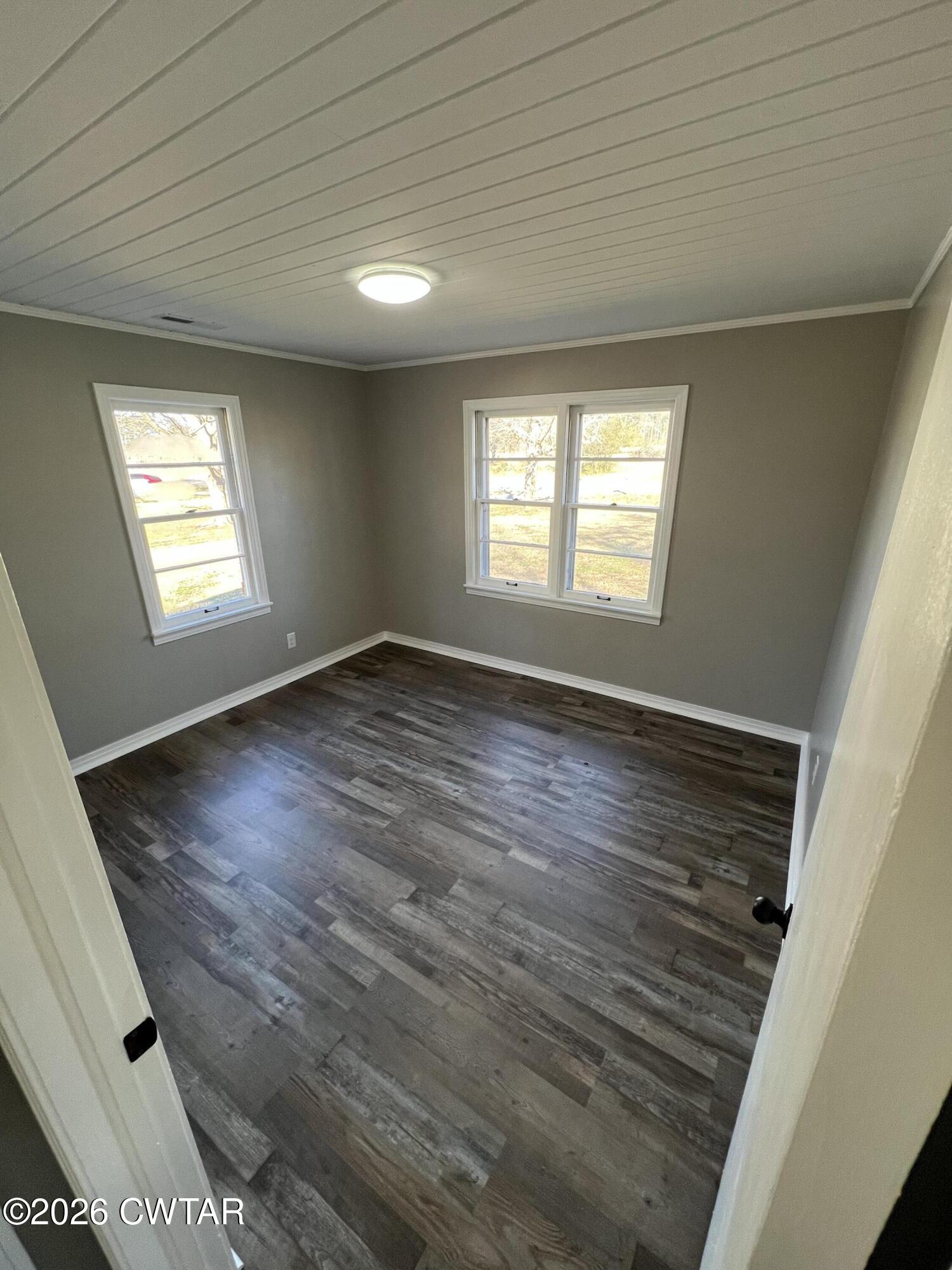 2094 Old Stage Road Adamsville, TN 38310 - Photo 12 of 12 an empty room with wooden floor and windows