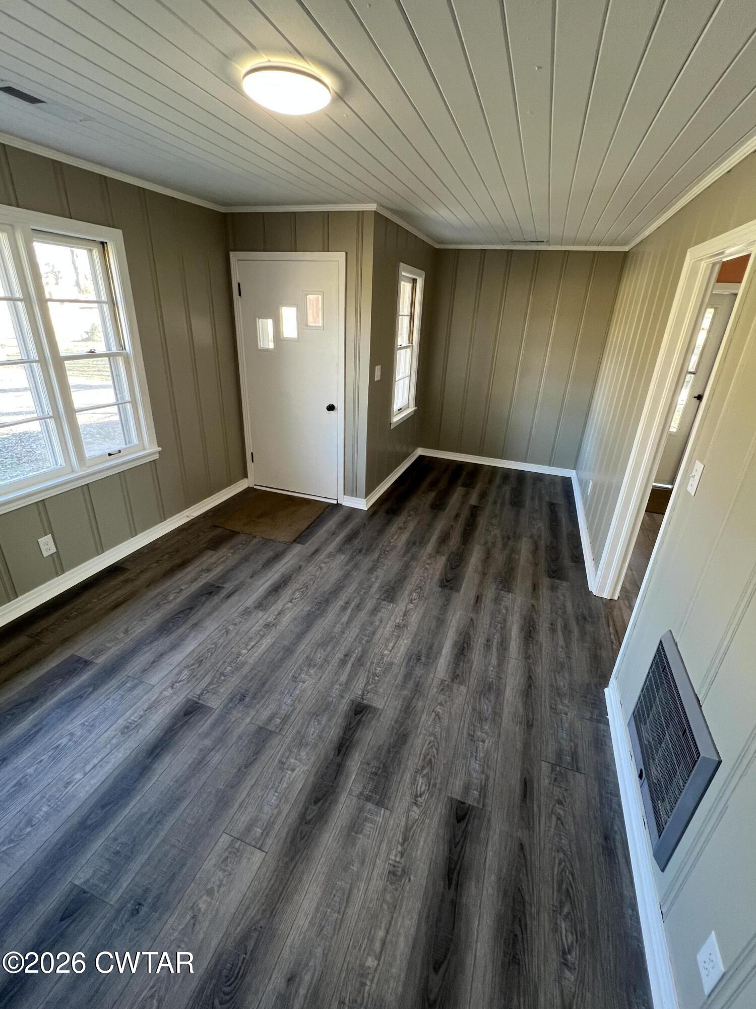 2094 Old Stage Road Adamsville, TN 38310 - Photo 4 of 12 a view of an empty room with wooden floor and a window