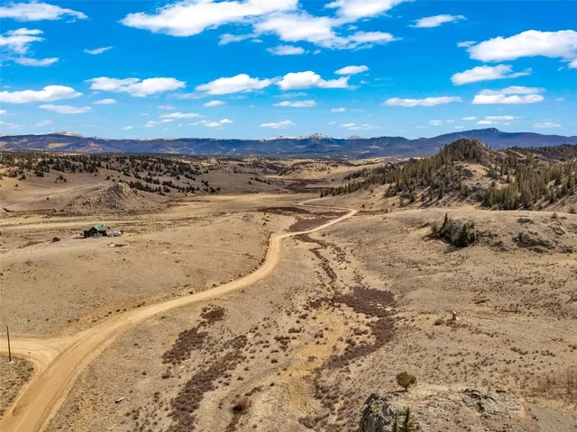 a view of a dry yard with wooden fence