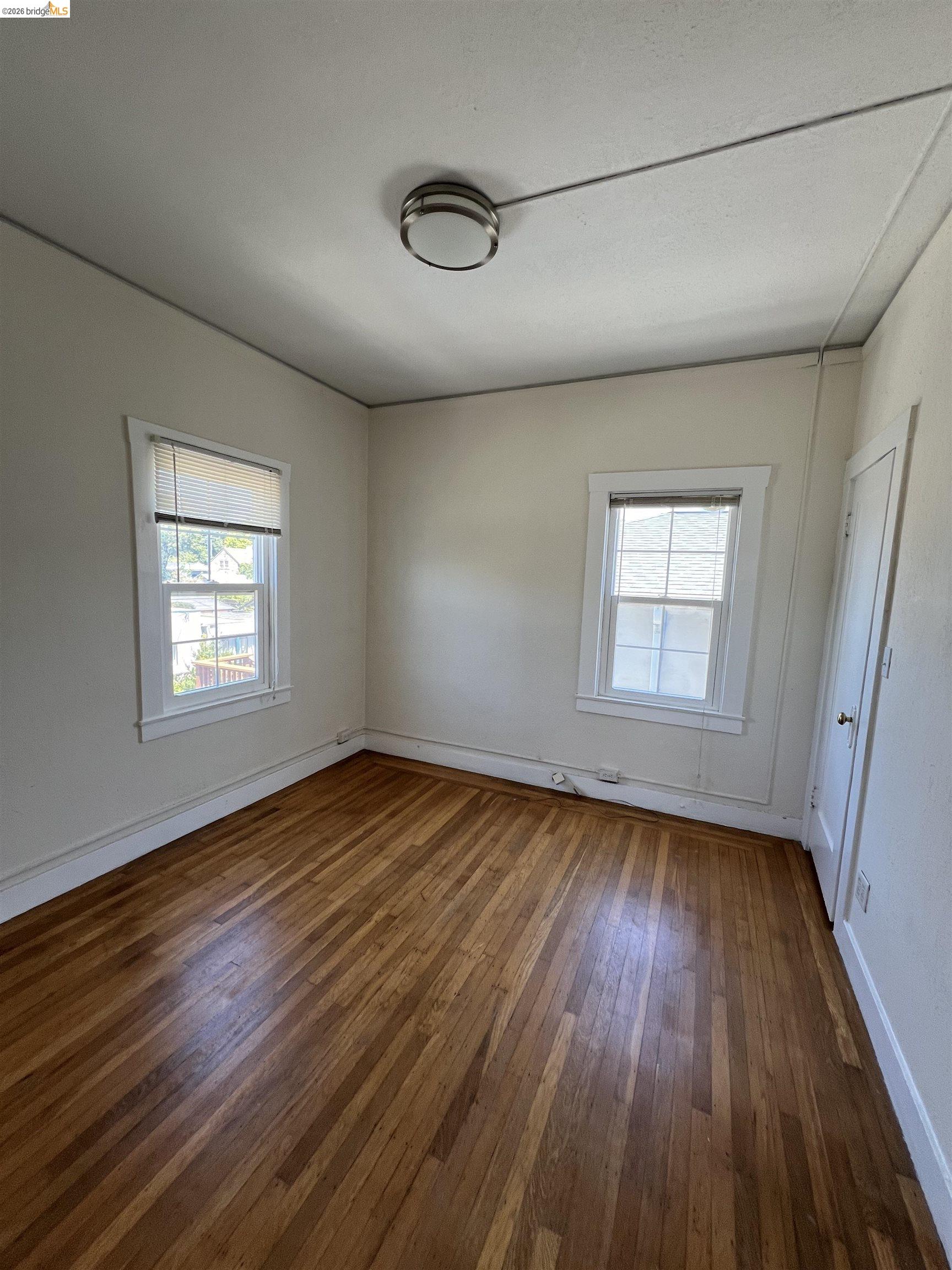 2249 Spaulding Avenue, Unit 4 Berkeley, CA 94703 - Photo 2 of 4 an empty room with wooden floor and windows