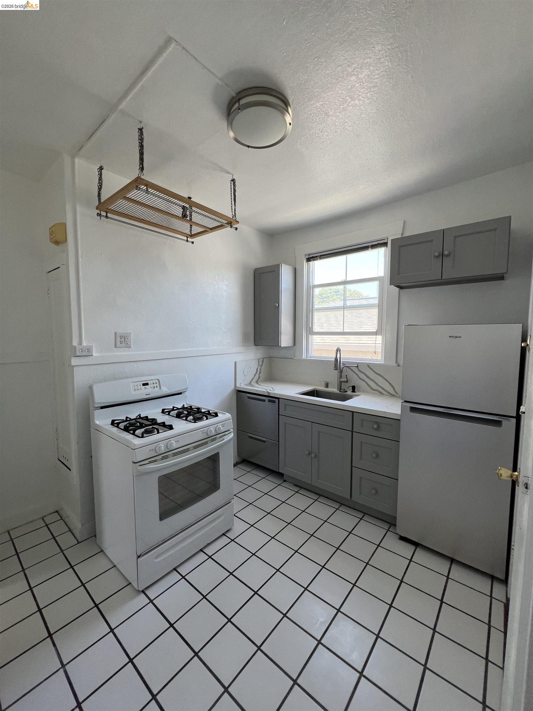 2249 Spaulding Avenue, Unit 4 Berkeley, CA 94703 - Photo 3 of 4 a kitchen with a stove sink and cabinets