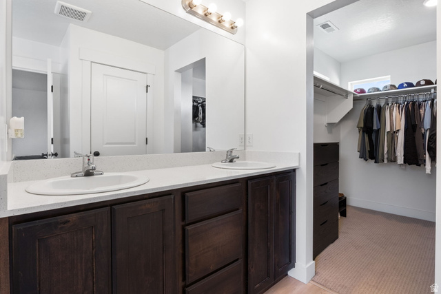 815 West Powderwood Lane Mapleton, UT 84664 - Photo 26 of 34 Bathroom vanity with dual undermount sinks, light-toned countertop, and dark wood-finish cabinetry