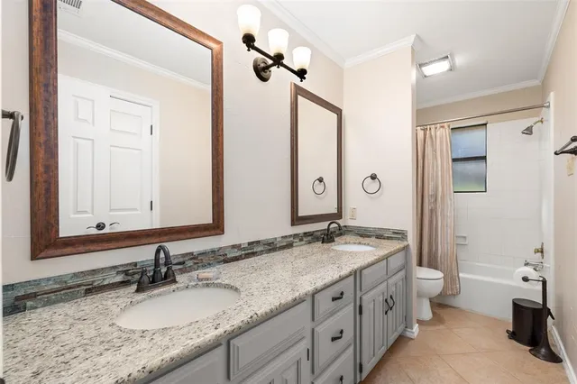 a kitchen with stainless steel appliances granite countertop wooden cabinets a stove a sink a dining table and chairs