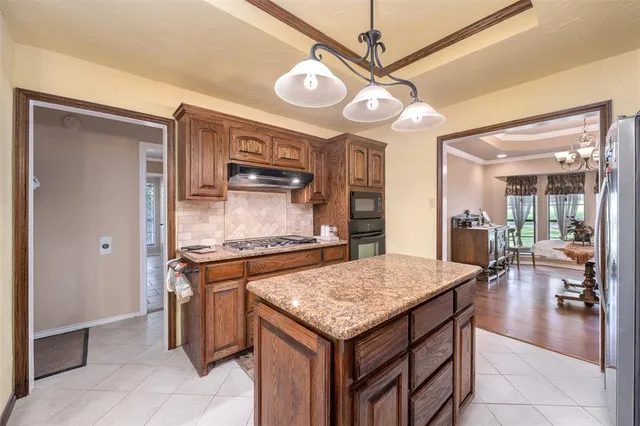 a large kitchen with kitchen island granite countertop a large counter top appliances and cabinets