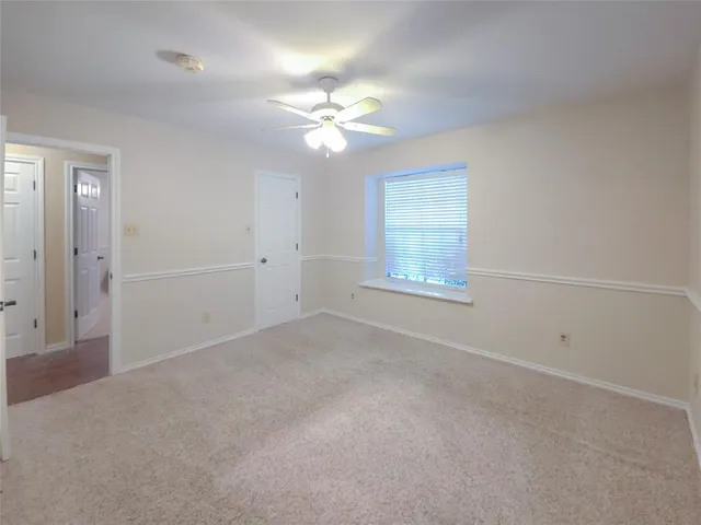 a living room with furniture a flat screen tv and a floor to ceiling window