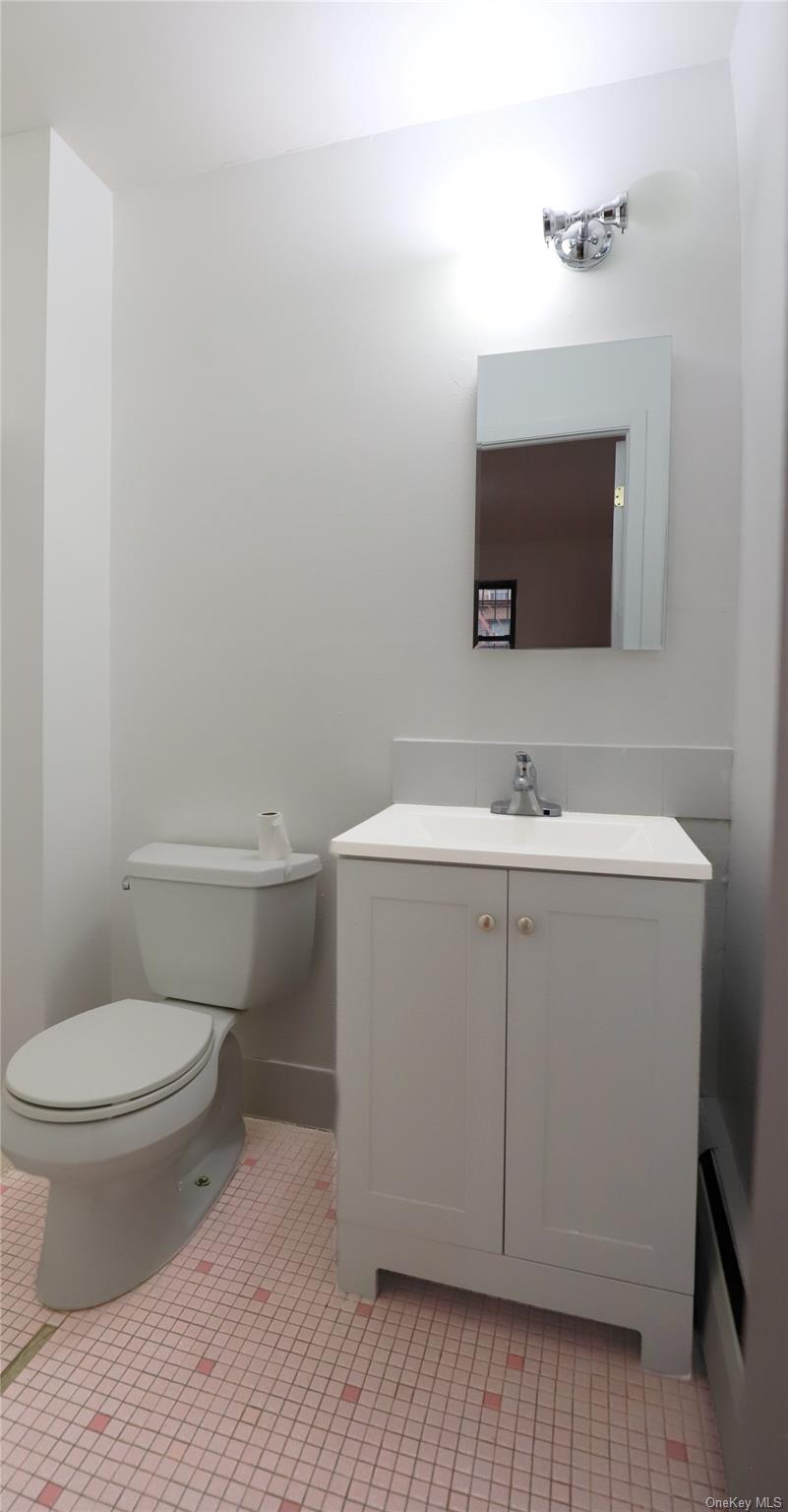 57-32 Xenia Street Queens, NY 11368 - Photo 10 of 12 a bathroom with a sink toilet and mirror
