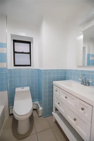 a bathroom with a toilet a sink and mirror