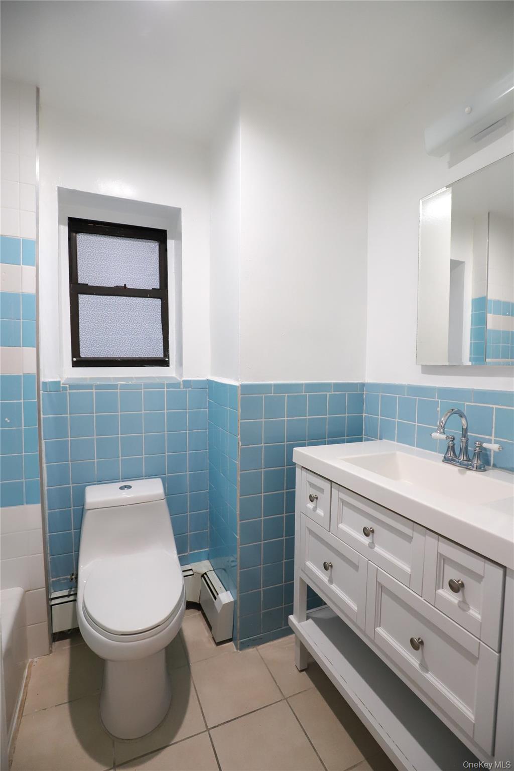 57-32 Xenia Street Queens, NY 11368 - Photo 3 of 12 a bathroom with a toilet a sink and mirror