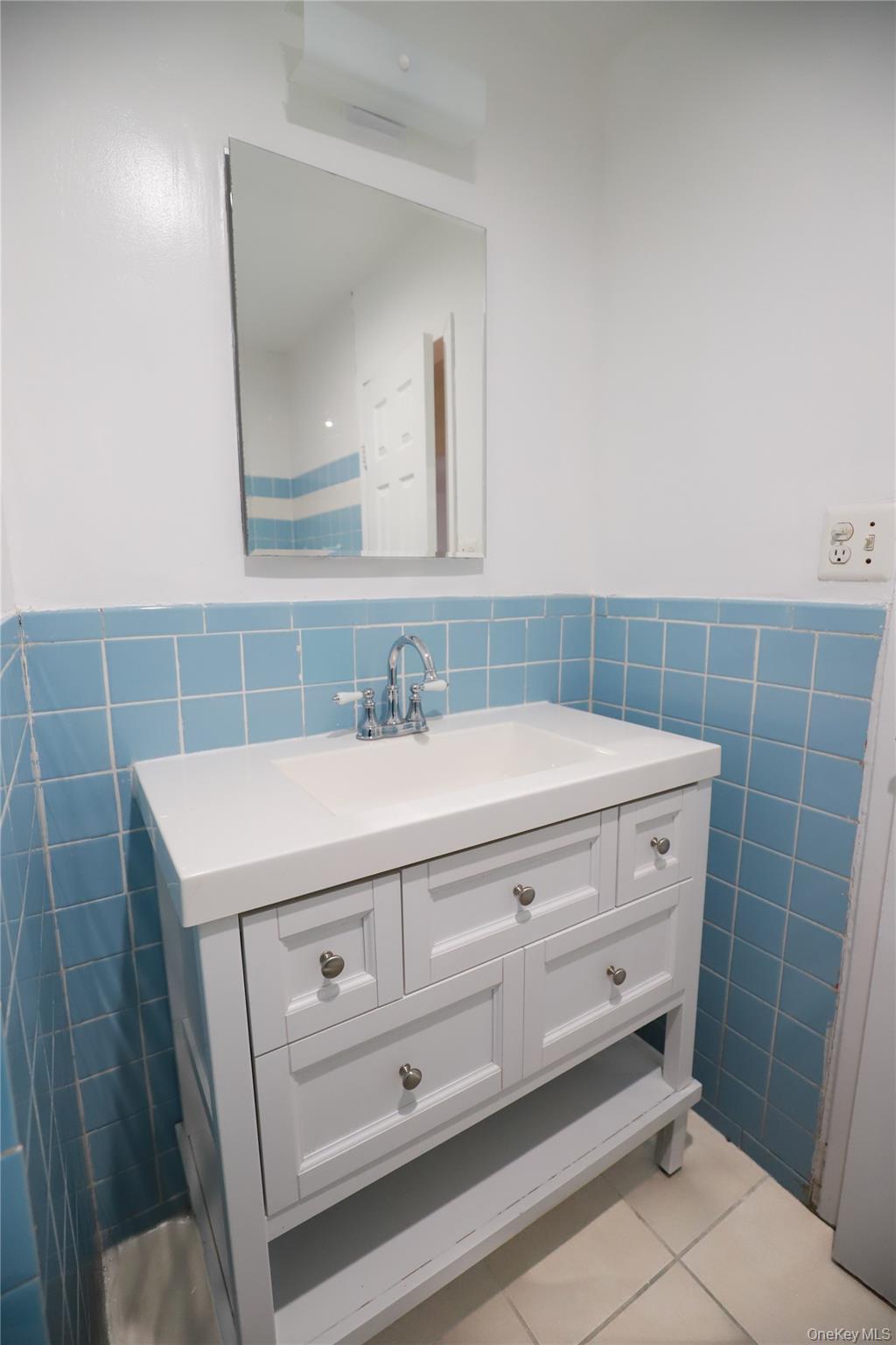 57-32 Xenia Street Queens, NY 11368 - Photo 5 of 12 a bathroom with a sink a vanity and a mirror