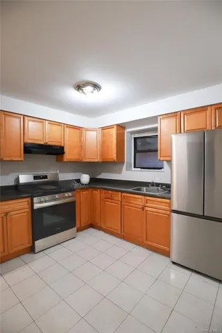 a kitchen with stainless steel appliances granite countertop a stove a sink and a refrigerator