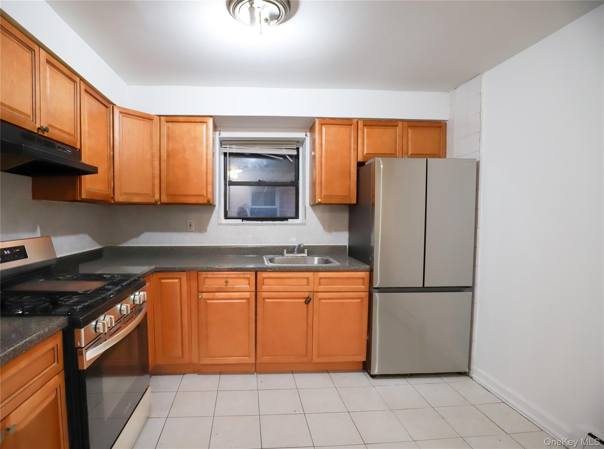 57-32 Xenia Street Queens, NY 11368 - Photo 9 of 12 a kitchen with stainless steel appliances granite countertop a refrigerator a stove and a sink