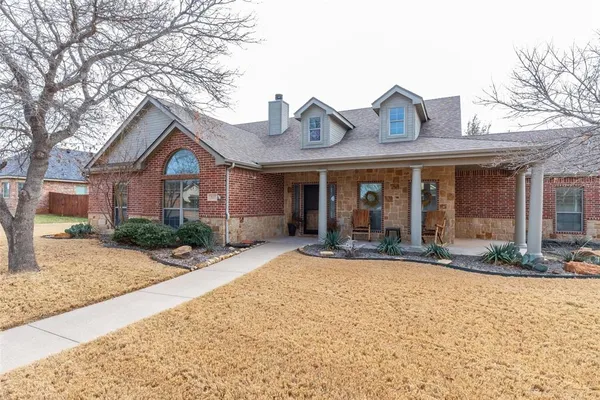 a front view of a house with a yard and glass windows