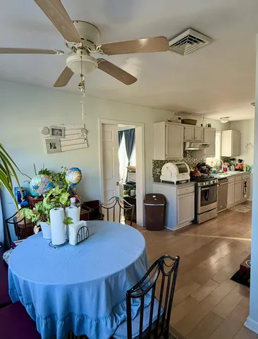 a kitchen with a dining table chairs stainless steel appliances and cabinets