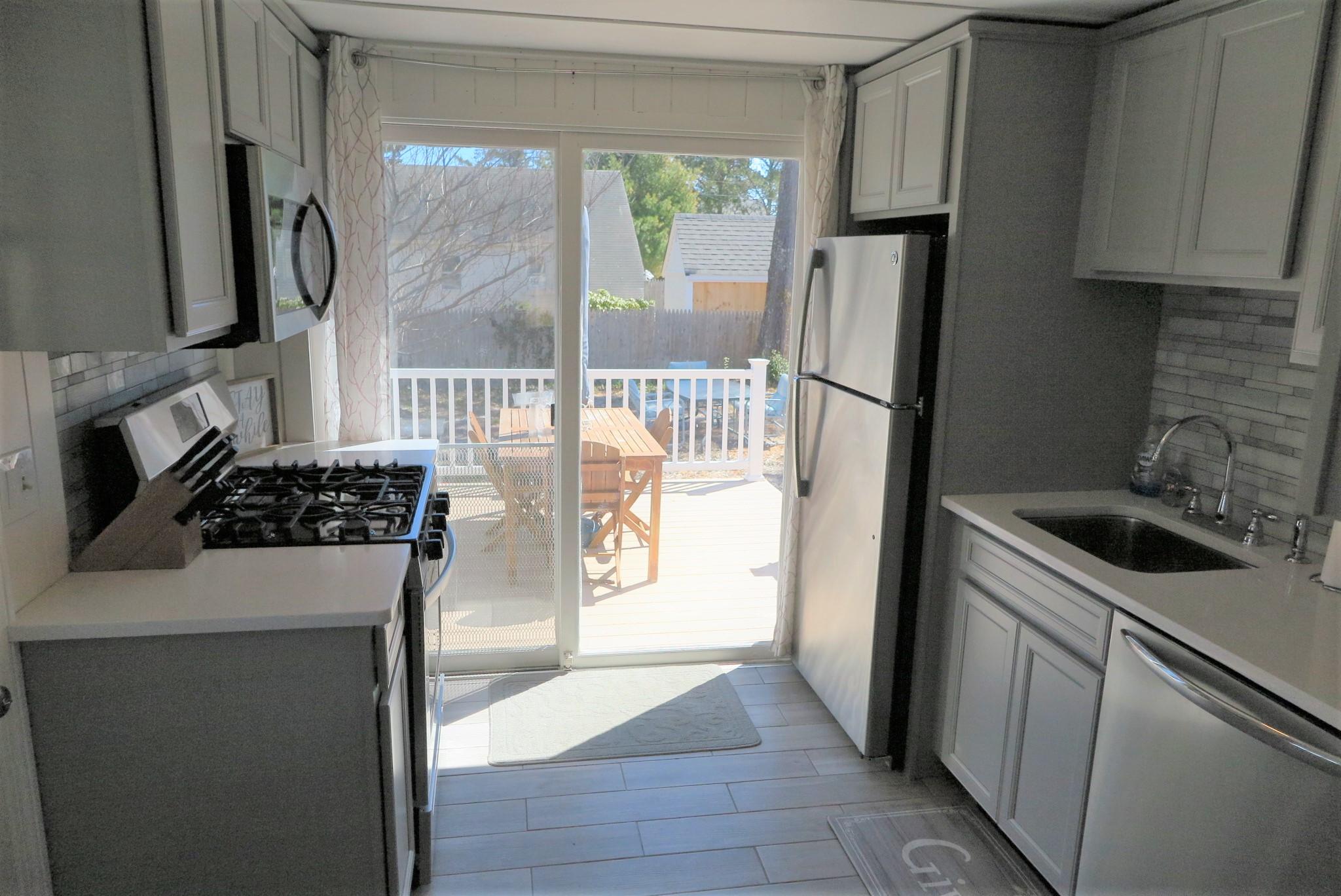 42 Bain Road Dennis Port, MA 02639 - Photo 12 of 46 a kitchen with a refrigerator sink and stove