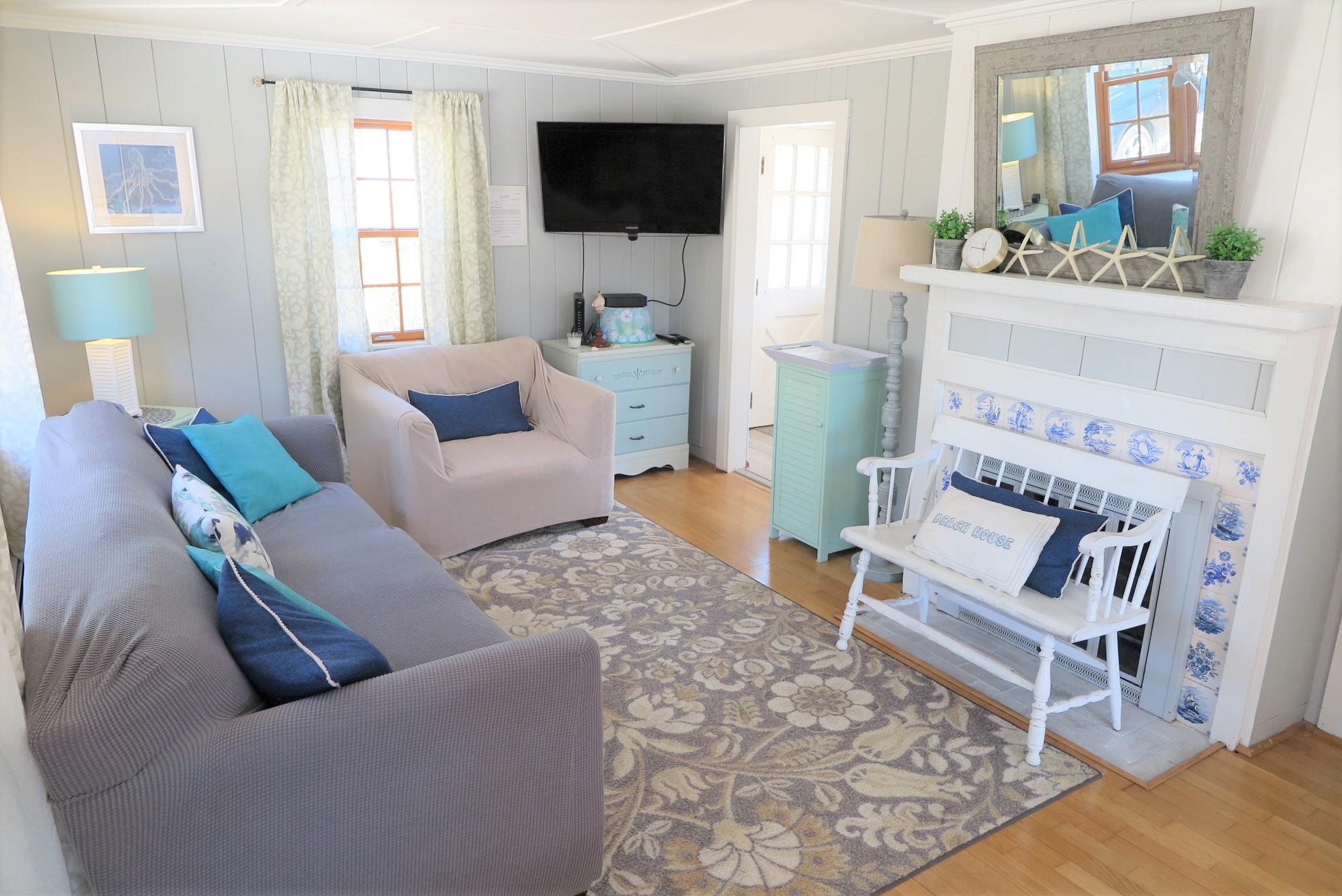 42 Bain Road Dennis Port, MA 02639 - Photo 5 of 46 a living room with furniture a flat screen tv and a fireplace
