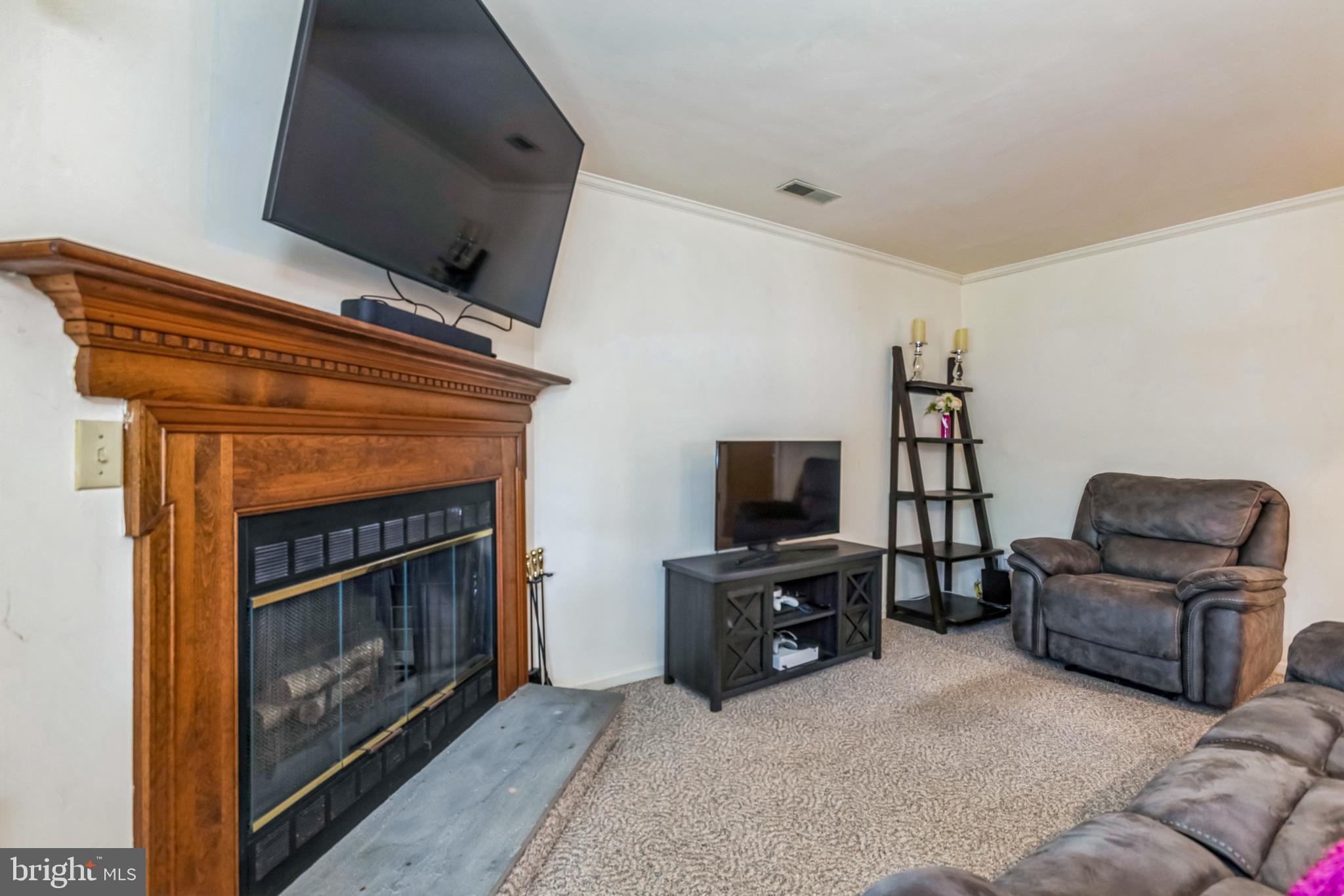 103 Upper Valley Lane Newark, DE 19711 - Photo 12 of 31 a living room with furniture a flat screen tv and a fireplace