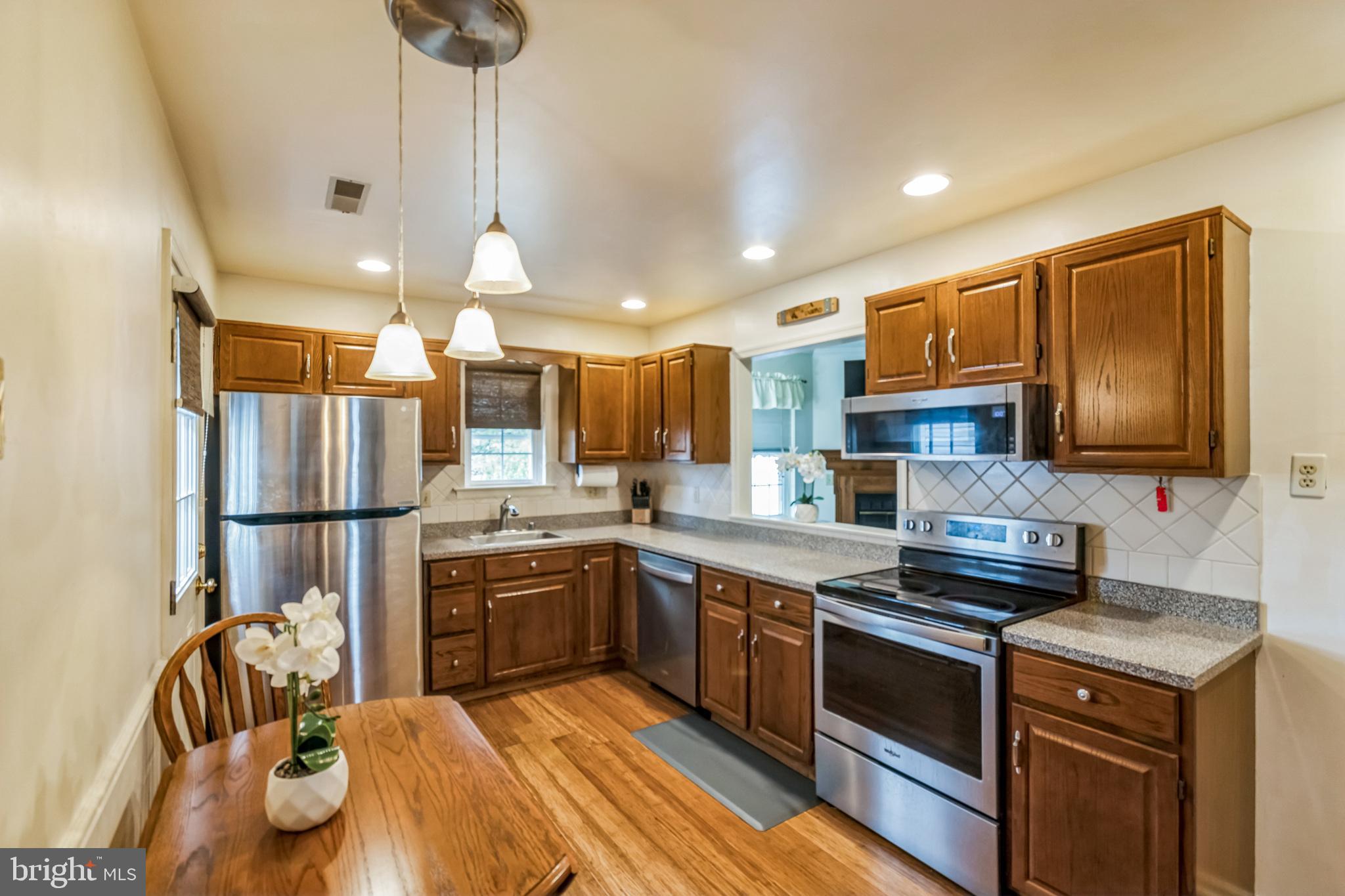 103 Upper Valley Lane Newark, DE 19711 - Photo 6 of 31 a kitchen with stainless steel appliances granite countertop a stove a sink a refrigerator and a microwave