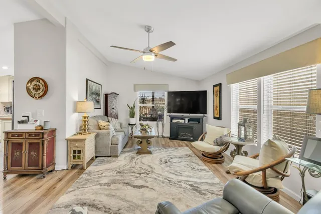 a living room with furniture a flat screen tv and a large window