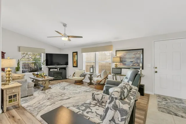 a living room with furniture a flat screen tv and a fireplace