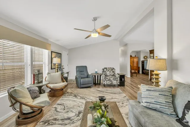 a living room with furniture ceiling fan and a window