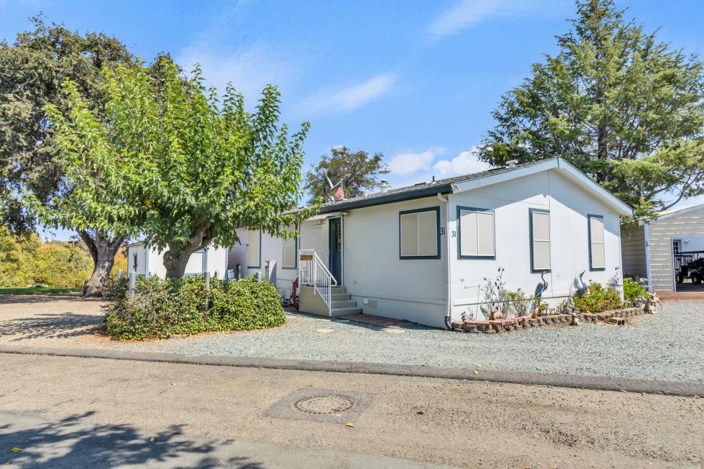 2000 Camanche Road, Unit 31 Ione, CA 95640 - Photo 9 of 43 a white house with a yard and plants