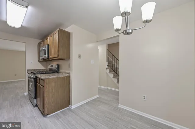 a kitchen with stainless steel appliances granite countertop a sink stove and wooden floor