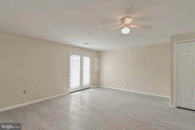 a view of an empty room with wooden floor and window