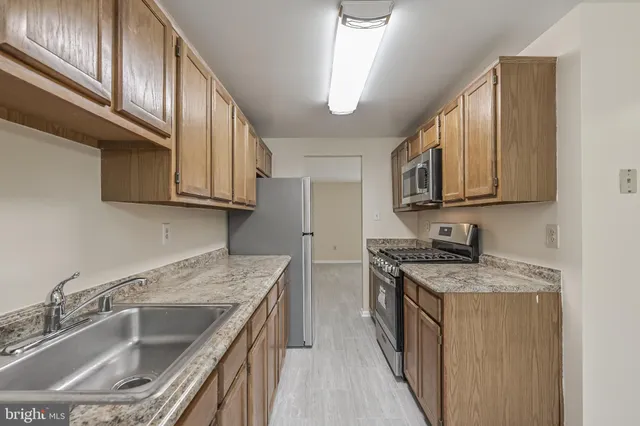 a kitchen with stainless steel appliances granite countertop a sink stove and cabinets