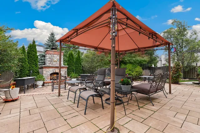 a view of the patio with couches and table under an umbrella