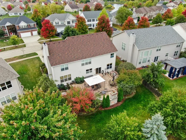 an aerial view of a house with a garden and lake view