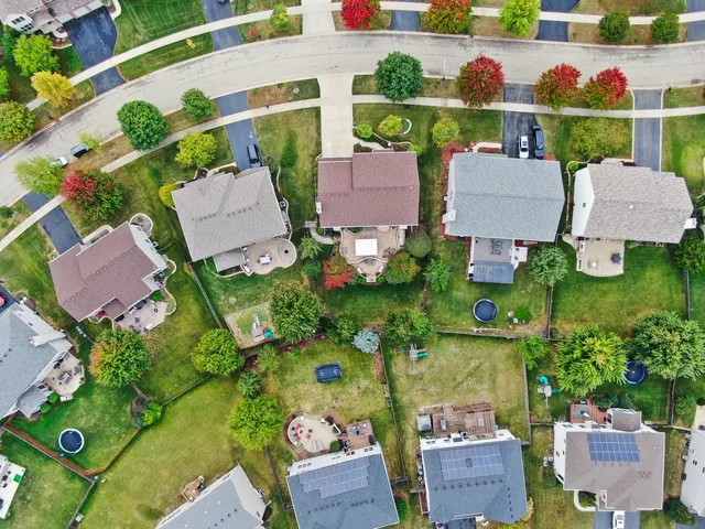 an aerial view of a house with a yard and lake view