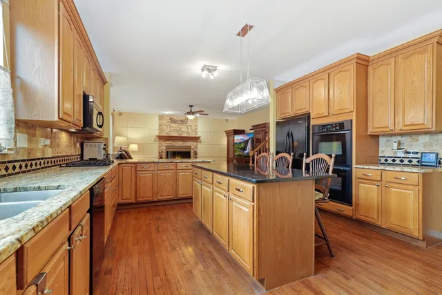 a kitchen with kitchen island granite countertop lots of counter top space and stainless steel appliances
