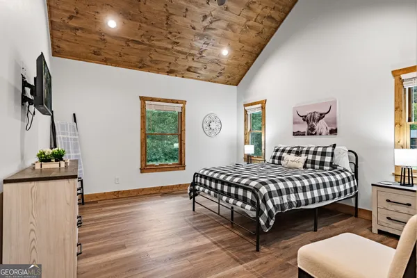 a bedroom with a bed and a flat tv screen on the dresser