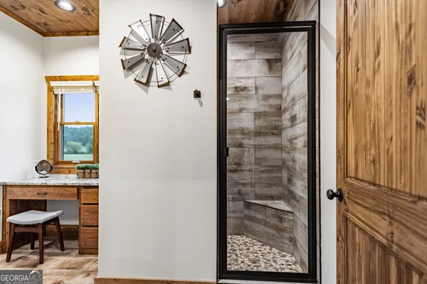 a view of a hallway with wooden floor and furniture