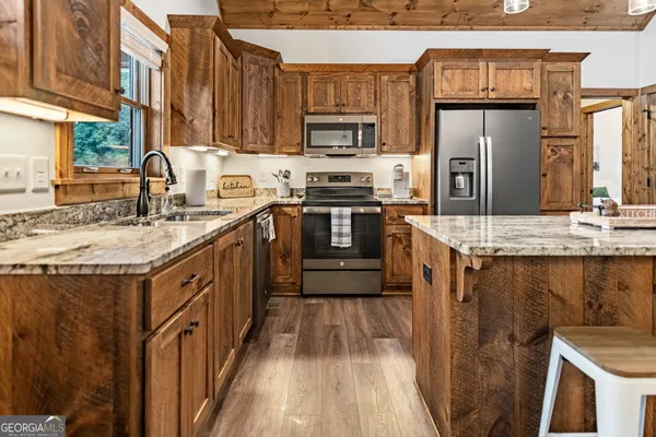 a kitchen with stainless steel appliances granite countertop a sink stove and refrigerator