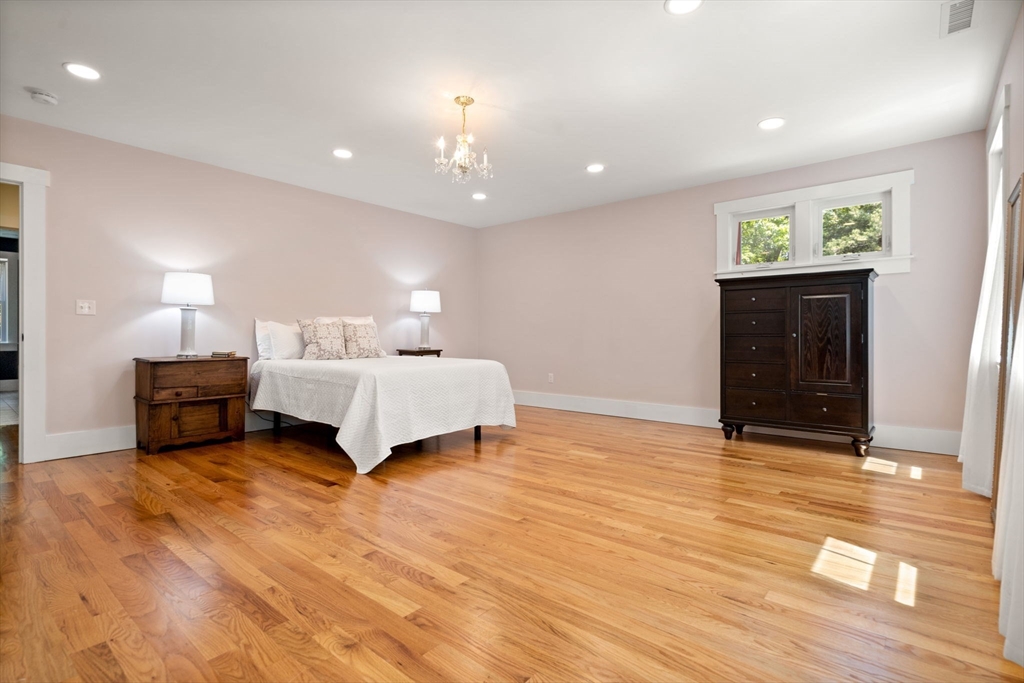158 Warren Road Townsend, MA 01469 - Photo 24 of 41 a spacious bedroom with a bed and a chandelier