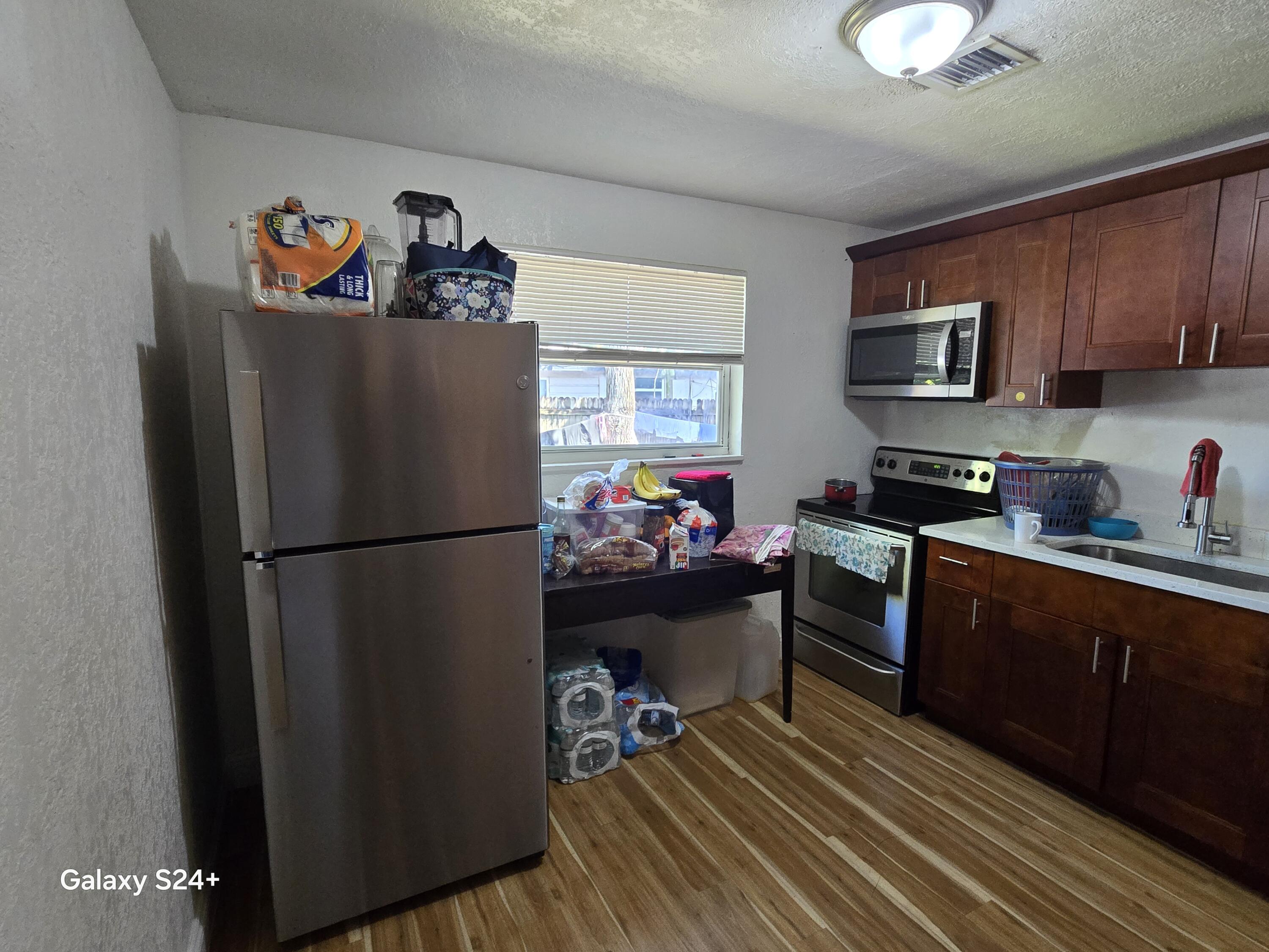 4258 Coconut Road Lake Worth, FL 33461 - Photo 6 of 14 a kitchen with stainless steel appliances a refrigerator sink and a cabinets