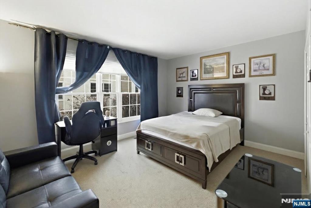 214 The Promenade, Unit 214 Edgewater, NJ 07020 - Photo 27 of 36 a bedroom with a bed a chair and potted plant with the dresser