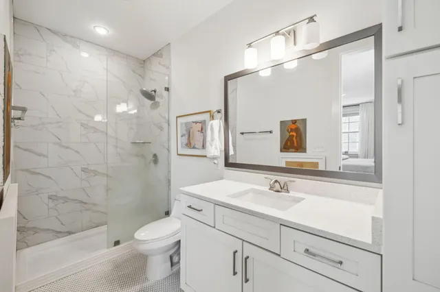 a bathroom with a sink a toilet and shower