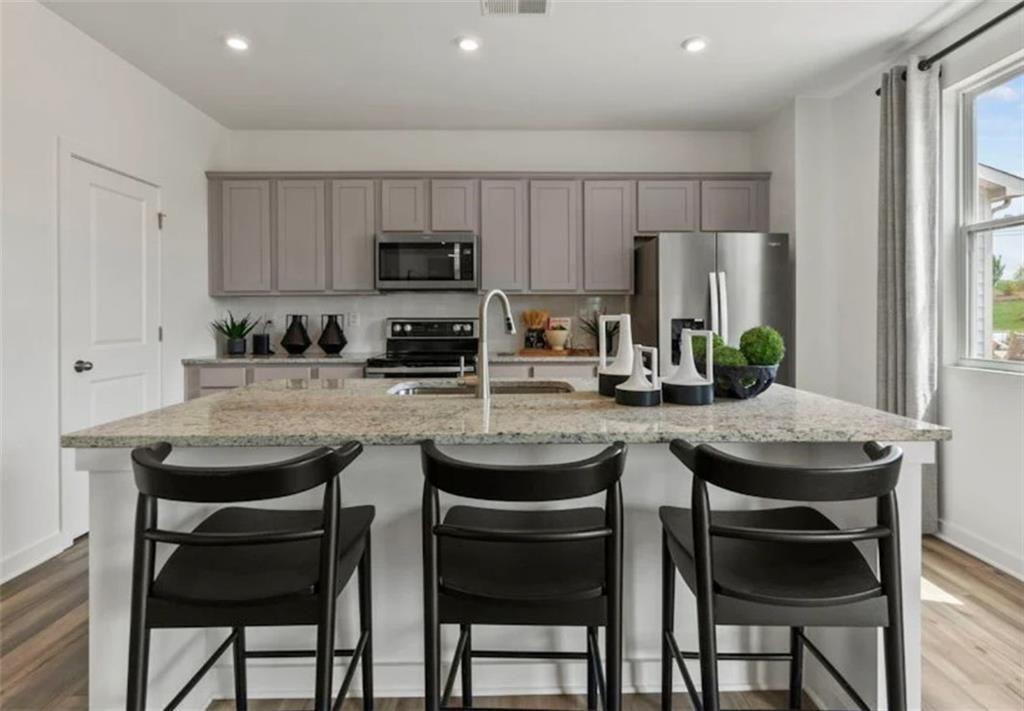 74 Poplar Blf Way Jefferson, GA 30549 - Photo 11 of 32 a kitchen with stainless steel appliances a table chairs refrigerator and microwave